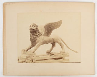 Stock ID #175451 [Sculpture or cast of a griffin on a wooden pallet with a small boy in the...