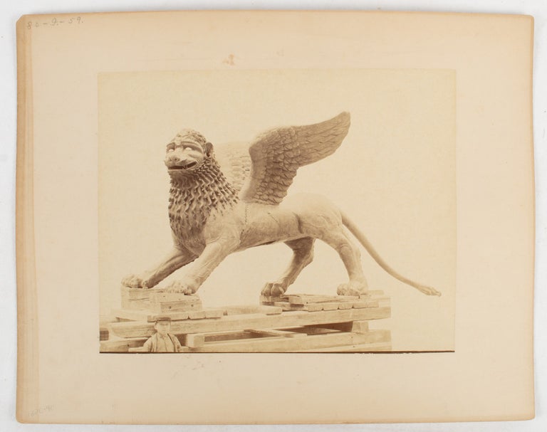 Stock ID #175451 [Sculpture or cast of a griffin on a wooden pallet with a small boy in the foreground.]. PHOTOGRAPHY.